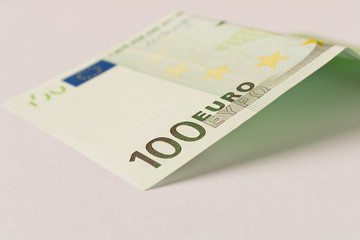 100 Euro banknote on a light background. Close up. The concept of savings.