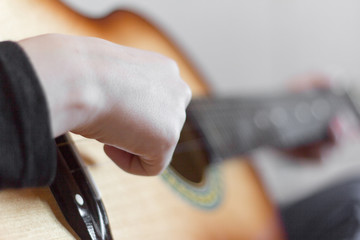 hand teen plays acoustic guitar,close-up