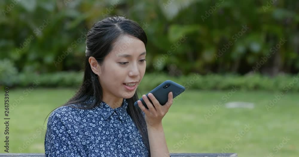 Canvas Prints Woman send voice message on cellphone in the park