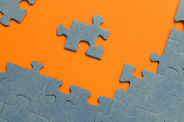 Fototapeta premium Abstract background of many puzzles on an orange background. The concept of teamwork.