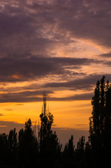 Landscape with dramatic light - beautiful golden sunset with saturated sky and clouds.