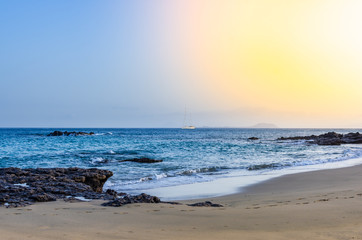 Fototapeta na wymiar Image of a beach with a sailboat crossing the horizon