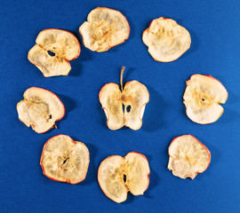 Apple chips laid out in circle on bright blue background.