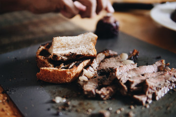 Blurred roast beef, corn, bread served on the table.