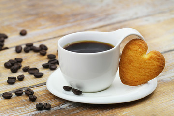 Cup of black coffee with heart shaped butter cookie with copy space