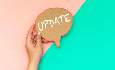 closeup hand holding update speech bubble