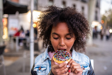 Cute Little Girl Eating a Donuts.