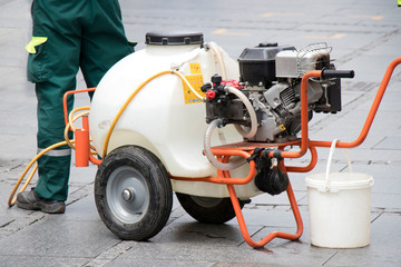 Fototapeta premium Watercart on wheels, portable watering system on pedestrian street