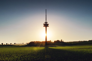 Obraz premium Antenna radio tower building at colorful evening sunset tones with shadows in the nature landscape view. Old town of Braunschweig, Germany