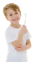 A little boy is brushing his teeth with a toothbrush.