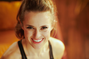 Fototapeta premium smiling fit woman in fitness clothes in modern house