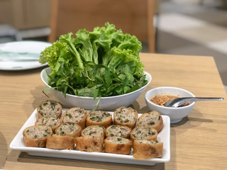 spring roll slice and salad with peanut sauce on the wooden table
