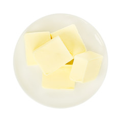 Close-up of fresh butter pieces on a white plate. Plate with butter isolated on white background. Sandwich butter. Natural fat nutrient.