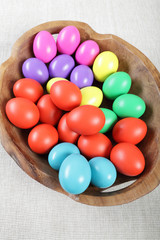 Multicoloured Easter eggs in a large wooden bowl