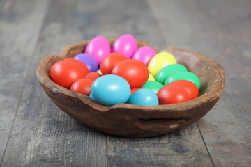 Fototapeta na wymiar Multicoloured Easter eggs in a beautiful wooden bowl