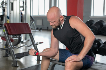 Fototapeta na wymiar Sport Exercise Trainer concept. bald man does exercises in morning in the gym. silver little dumbbells for training.