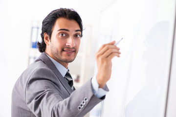 Young handsome businessman in front of whiteboard 