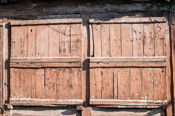 Old weathered grunge closed wooden boards window shutters of vintage country house