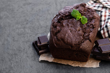 Homemade chocolate loaf cake on black stone background