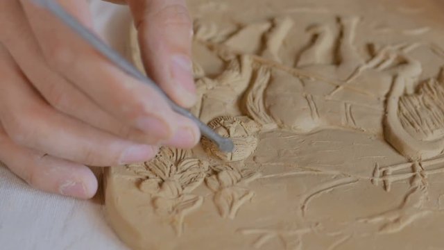 Professional male potter making clay stamp picture. Handwork, crafting and traditional arts concept