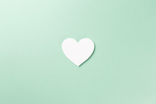 Creative photo. Valentine's Day postcard. Valentine's Day Background. Heart with confetti on Mint background. Copy space. Top view. Flat lay. Pastel colors. Neo Mint color of the year 2020