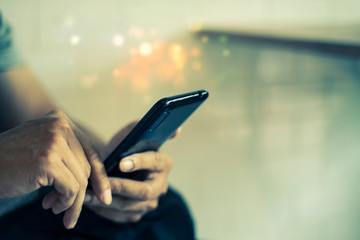 Closeup of hands using mobile in city.