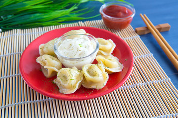 Delicious dumplings in the pot on the table Fresh boiled dumplings with hot steams on a plate