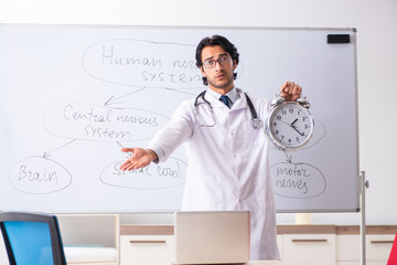 Young male doctor neurologist in front of whiteboard 