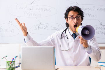 Young male doctor neurologist in front of whiteboard 