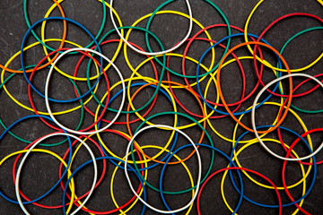 abstract background with colored rubber bands for money on black background