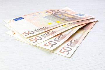 MONEY IN CASH ON WHITE WOOD BACKGROUND