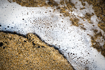 White foam of the sea on the beach