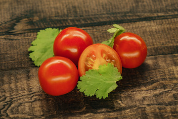 tasty red cherry tomatoes on wooden background.