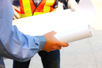 architect holding blank blueprints