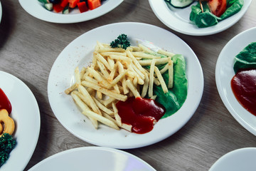 Plate with French fries and sauce on the table