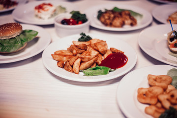 rustic potatoes with sauce and other dishes on the table