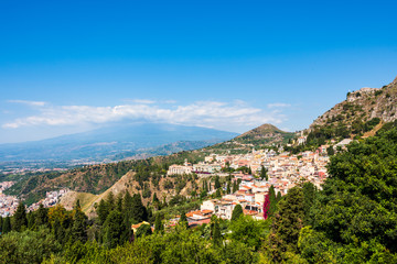 Fototapeta na wymiar Stadtansicht von Taormina in Sizilien mit dem wolkenverhangenen Vulkan Ätna