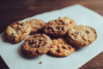 Biscuits with chocolate and peanut on old wooden table. Selective focus.