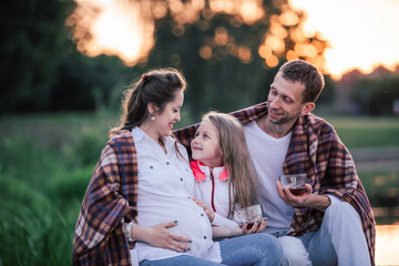 Obraz premium happy family with cups of tea on a picnic on a cool day