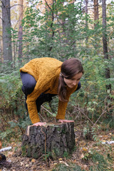 Female model doing yoga in the autumn forest.