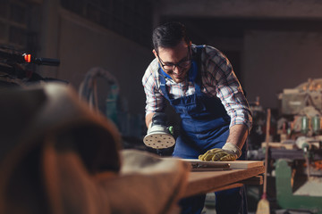 Carpenter Using Electric Sander for wood 