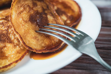 Fresh homemade pancakes with liquid honey and maple syrup, closeup toned photo