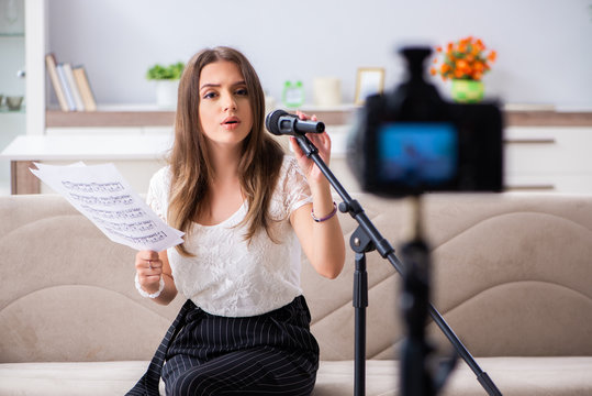Female beautiful blogger singing at home 