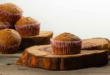 homemade muffins with coconut chips on a wooden stand