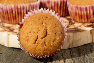 homemade muffins with coconut chips on a wooden stand