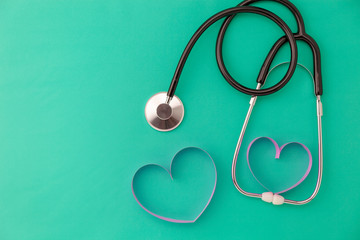 World health day background,Stethoscope and pink ribbon heart on green background,Concept healthcare and medical background