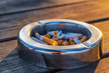 ashtray with cigarette butts on a wooden table