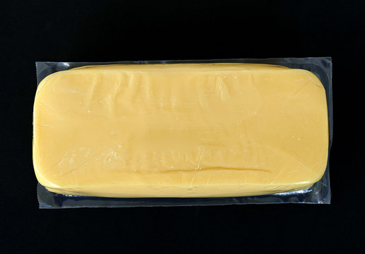 Cheddar Cheese In 1 Kg Package, On Black Background