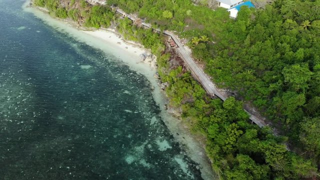 Aerial: Flying over tropical beach turquoise water coral reef , Tomia island Wakatobi National Park Indonesia Maldives Polynesia white sand beach. Native cinelike D-log color profile