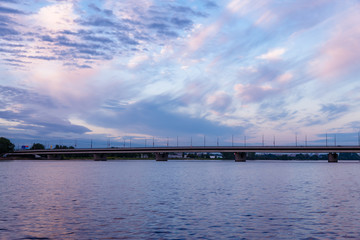 view of the island bridge across the blue river Daugava, at the back is a beautiful blue sky with different types and colors of clouds